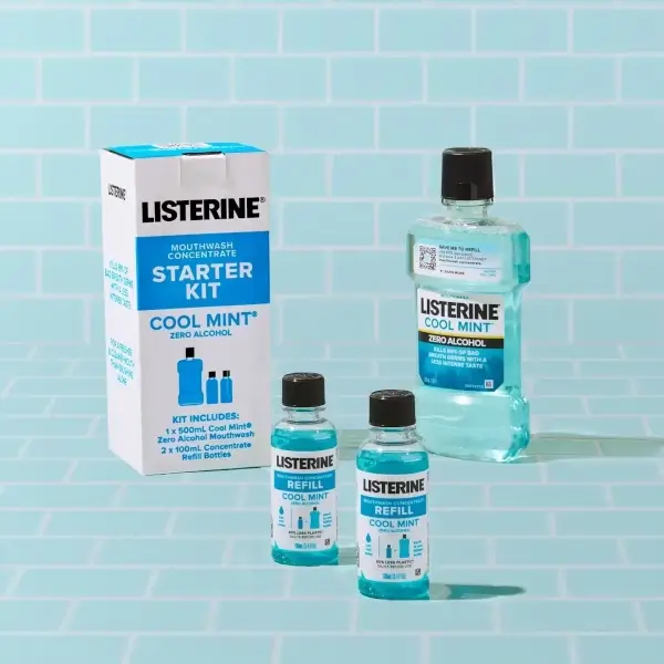 Un paquete de kit inicial del enjuague bucal concentrado Cool Mint Zero, que incluye 2 botellas pequeñas de repuesto. Además, se muestra una botella de Listerine Cool Mint Zero sobre un fondo de azulejos azul claro.